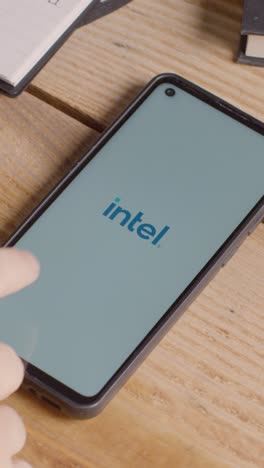 Vertical-Video-Of-Mobile-Phone-On-Desk-With-Screen-Showing-Brand-Logos-For-Microsoft,Intel,IBM,nVidia,Adobe-and-Qualcomm