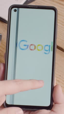 Vertical-Video-Of-Hand-Holding-Mobile-Phone-With-Screen-Showing-Brand-Logos-For-Apple,Google,McDonalds,Microsoft,Tesla,Verizon,Visa,Amazon,AT&T-And-Mastercard