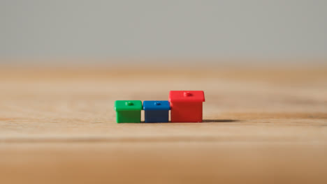Home-Buying-Concept-With-Red-Blue-And-Green-Plastic-Model-Of-Houses-On-Wooden-Surface-1