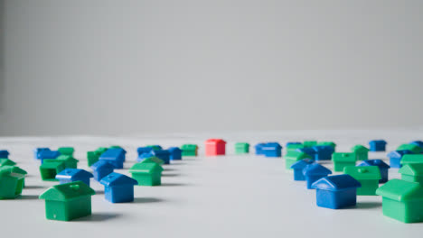 Hauskaufkonzept-Mit-Entwicklung-Von-Roten,-Blauen-Und-Grünen-Kunststoffmodellen-Von-Häusern-Auf-Weißem-Hintergrund