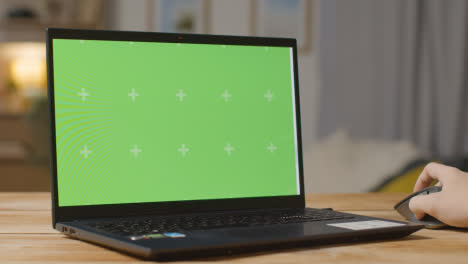 Person-At-Online-Looking-At-Green-Screen-Website-On-Laptop