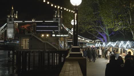 Concurridos-Puestos-Del-Mercado-Navideño-Mirando-Hacia-El-Puente-De-La-Torre-En-La-Orilla-Sur-De-Londres-Por-La-Noche