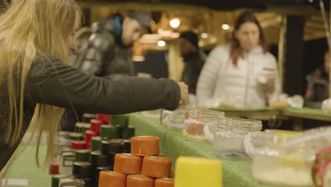 Nahaufnahme-Kunden-Am-Stall,-Der-Käse-Auf-Dem-Weihnachtsmarkt-Am-Londoner-Südufer-In-Der-Nacht-Verkauft