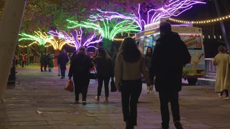 Gente-Caminando-Junto-A-árboles-Decorados-Con-Luces-Navideñas-A-Lo-Largo-De-South-Bank-En-Londres-Por-La-Noche