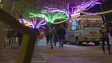 Gente-Caminando-Junto-A-árboles-Decorados-Con-Luces-Navideñas-A-Lo-Largo-De-South-Bank-En-Londres-Por-La-Noche-1