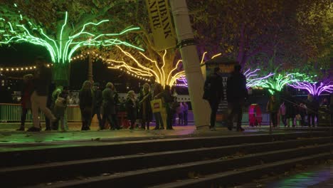 Menschen,-Die-Bei-Nacht-An-Weihnachtlich-Beleuchteten-Bäumen-Am-Südufer-In-London-Vorbeigehen-4