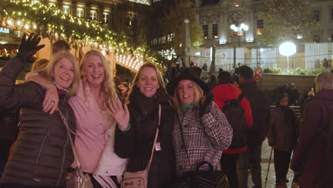 Gruppe-Von-Freundinnen,-Die-Nachts-Auf-Dem-Frankfurter-Weihnachtsmarkt-In-Victoria-Square-Birmingham-Uk-Für-Die-Kamera-Posieren