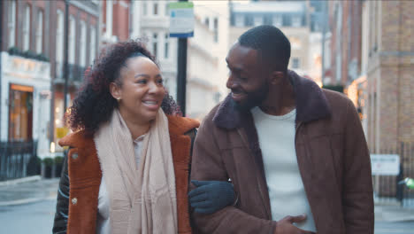 Couple-Walking-Arm-In-Arm-Through-Street-On-Winter-Visit-To-London-2
