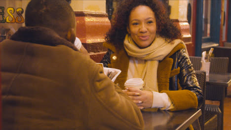 Reunión-De-Pareja-Para-Una-Bebida-Caliente-En-La-Mesa-En-Un-Café-Al-Aire-Libre-En-Leadenhall-Market,-Londres,-Gran-Bretaña.