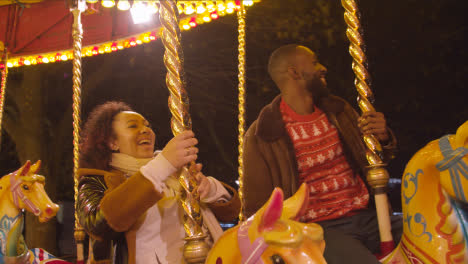 Pareja-Divirtiéndose-Montando-En-La-Rotonda-Del-Recinto-Ferial-En-El-Banco-Sur-De-Londres-Por-La-Noche-1