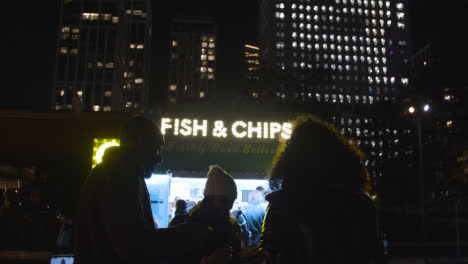Customers-In-Front-Of-Fish-And-Chip-Stall-On-London-South-Bank-At-Night-