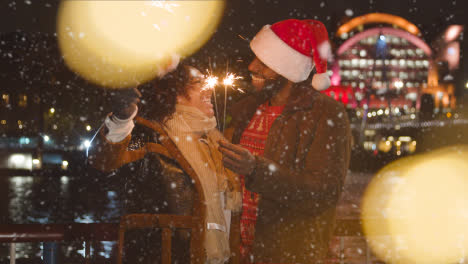 Paar-Feiert-Weihnachten-Oder-Neujahr-Mit-Wunderkerzen,-Während-Es-In-London-Schneit
