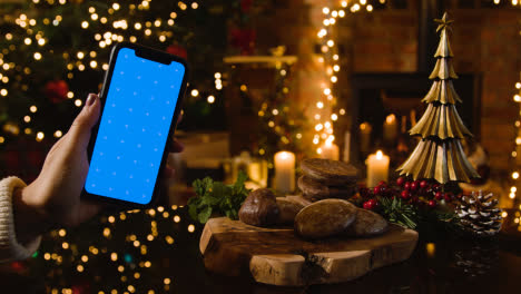 Christmas-At-Home-With-Traditional-German-Christmas-Lebkuchen-And-Person-With-Blue-Screen-Mobile-Phone-2