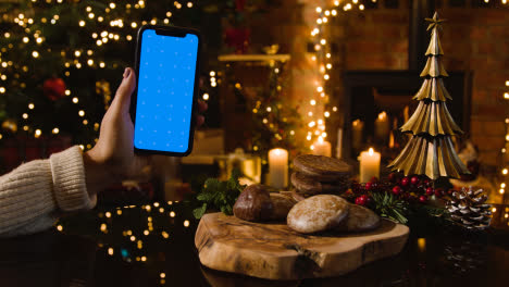 Christmas-At-Home-With-Traditional-German-Christmas-Lebkuchen-And-Person-With-Blue-Screen-Mobile-Phone-3