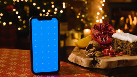 Weihnachtsessen-Zu-Hause-Und-Traditioneller-Weihnachtskuchen-Und-Handy-Mit-Blauem-Bildschirm