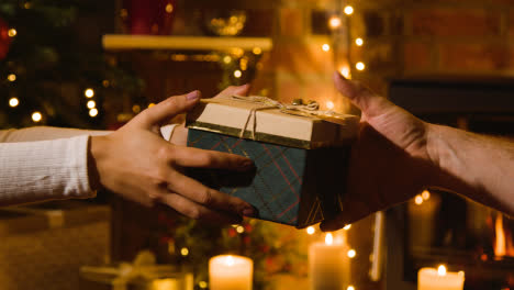 Nahaufnahme-Eines-Paares-Zu-Hause,-Das-Weihnachtsgeschenke-Vor-Einem-Feuer-Austauscht-1