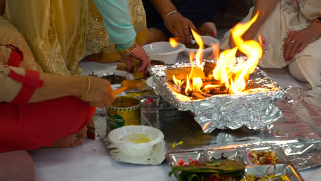 Anbeter,-Die-Während-Der-Hinduistischen-Havan-Zeremonie-Ghee-Und-Opfergaben-Auf-Feuerflammen-Legen