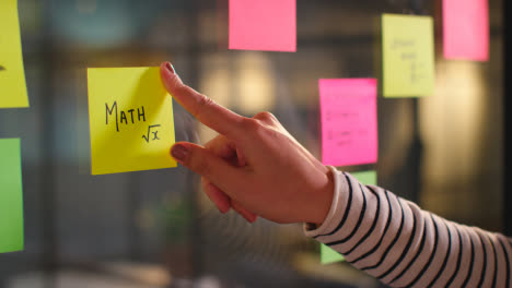Close-Up-Of-Woman-Putting-Sticky-Note-With-Math-Written-On-It-Onto-Transparent-Screen-In-Office-1