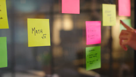 Close-Up-Of-Woman-Putting-Sticky-Note-With-Math-Written-On-It-Onto-Transparent-Screen-In-Office-2