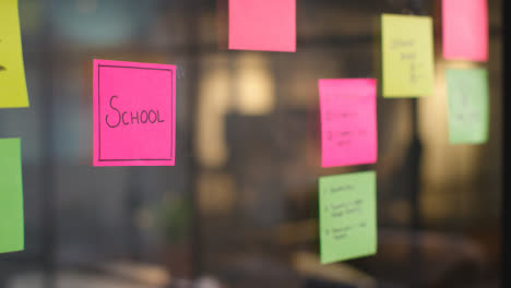 Close-Up-Of-Woman-Putting-Sticky-Note-With-School-Written-On-It-Onto-Transparent-Screen-In-Office-2