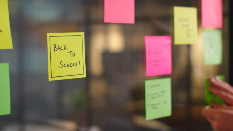 Close-Up-Of-Woman-Putting-Sticky-Note-With-Back-To-School-Written-On-It-Onto-Transparent-Screen-In-Office-2