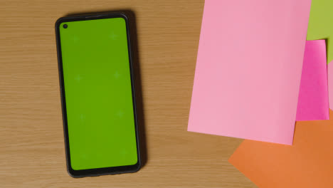 Business-Concept-Of-Revolving-Sticky-Notes-With-Business-And-Financial-Terms-And-Green-Screen-Mobile-Phone