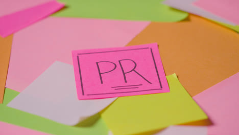 Business-Concept-Of-Revolving-Sticky-Notes-With-PR-Written-On-Top-Note-1