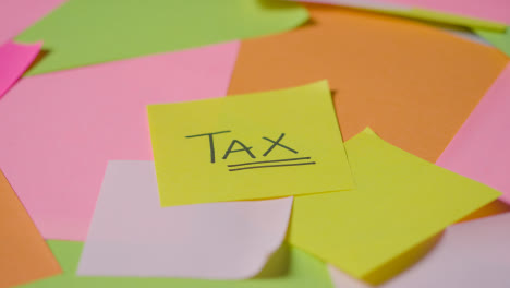 Business-Concept-Of-Revolving-Sticky-Notes-With-Tax-Written-On-Top-Note-1