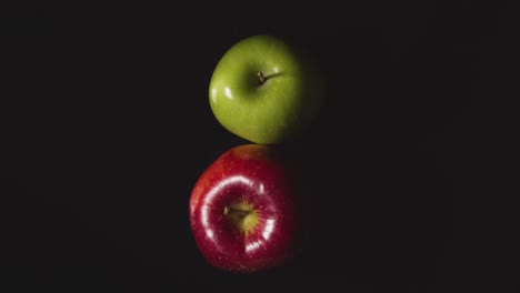 Overhead-Studioaufnahme-Von-Roten-Und-Grünen-Äpfeln,-Die-Sich-Vor-Schwarzem-Hintergrund-Drehen-1