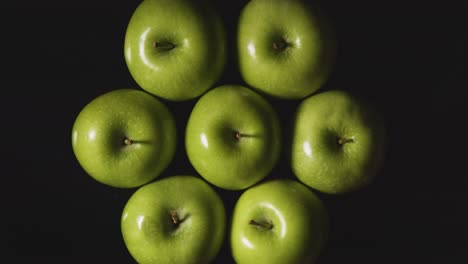 Fotografía-Aérea-De-Estudio-De-Manzanas-Verdes-Girando-Sobre-Fondo-Negro