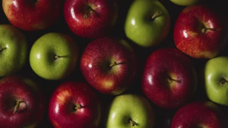 Obenliegende-Studioaufnahme-Von-Roten-Und-Grünen-Äpfeln,-Die-Sich-Vor-Schwarzem-Hintergrund-Drehen