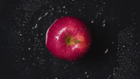 Overhead-Studio-Shot-Of-Red-Apple-With-Water-Droplets-Revolving-Against-Black-Background-1