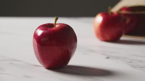 Foto-De-Estudio-De-Una-Bolsa-De-Papel-De-Manzanas-Rojas-En-La-Superficie-De-La-Cocina-De-Mármol