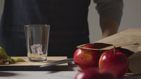 Jugo-De-Manzana-Que-Se-Vierte-En-Un-Vaso-Con-Hielo-Y-Manzanas-Recién-Cortadas