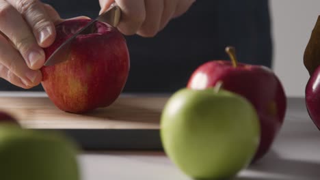 Nahaufnahme-Eines-Mannes,-Der-Frische-Äpfel-Auf-Einem-Schneidebrett-Schneidet-4