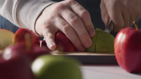 Primer-Plano-Del-Hombre-Cortando-Manzanas-Frescas-En-Una-Tabla-De-Cortar-6