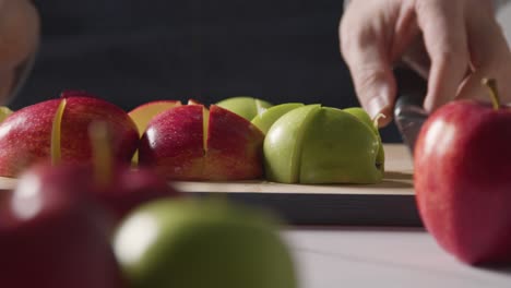 Cerca-De-Un-Hombre-Que-Lleva-Una-Tabla-De-Cortar-Con-Rodajas-De-Manzanas-Verdes-Y-Leídas