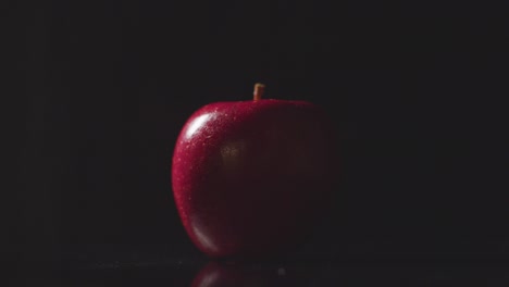 Foto-De-Estudio-De-Manzana-Roja-Girando-Sobre-Fondo-Negro