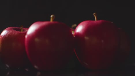 Studioaufnahme-Von-Roten-Und-Grünen-Äpfeln,-Die-Sich-Vor-Schwarzem-Hintergrund-Drehen