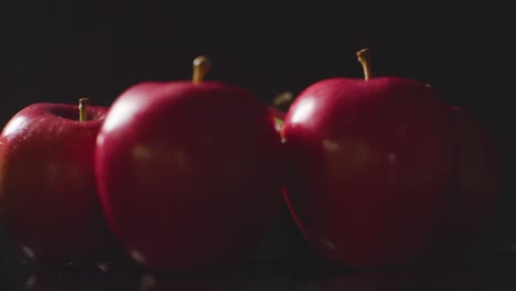 Foto-De-Estudio-De-Manzanas-Rojas-Y-Verdes-Girando-Sobre-Fondo-Negro