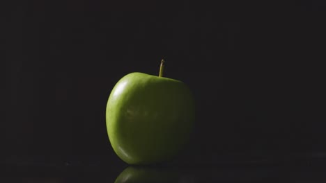 Foto-De-Estudio-De-Manzana-Verde-Girando-Sobre-Fondo-Negro