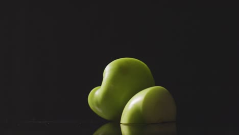 Studioaufnahme-Eines-Halbierten-Grünen-Apfels,-Der-Sich-Vor-Schwarzem-Hintergrund-Dreht