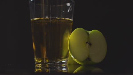 Studioaufnahme-Glas-Apfelsaft-Mit-Geschnittenen-Frischen-Äpfeln-Auf-Schwarzem-Hintergrund