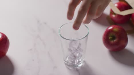 Jugo-De-Manzana-Que-Se-Vierte-En-Un-Vaso-Con-Hielo-Y-Una-Bolsa-De-Manzanas-Frescas