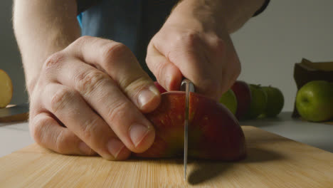 Primer-Plano-Del-Hombre-Cortando-Manzanas-Frescas-En-Una-Tabla-De-Cortar-1