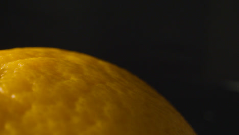 Macro-Studio-Shot-Of-Orange-Revolving-Against-Black-Background