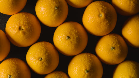 Fotografía-Aérea-De-Estudio-De-Naranjas-Con-Gotas-De-Agua-Sobre-Fondo-Negro