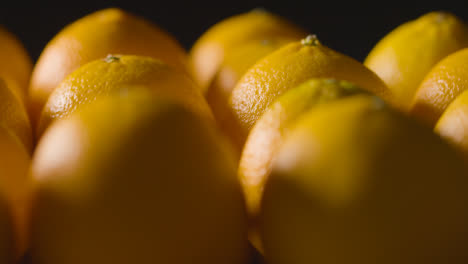 Close-Up-Studio-Shot-Of-Hand-Picking-From-Oranges-Revolving-Against-Black-Background