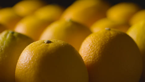 Primer-Plano-De-Estudio-De-Naranjas-Con-Gotas-De-Agua-Girando-Sobre-Fondo-Negro-1