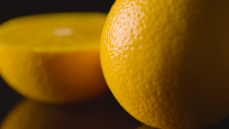 Close-Up-Studio-Shot-Of-Whole-And-Halved-Oranges-Revolving-Against-Black-Background-1